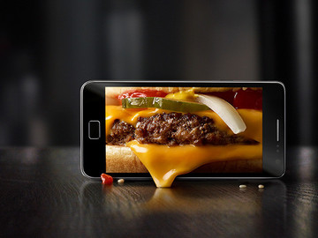 手机里的汉堡包美食创意摄影图片